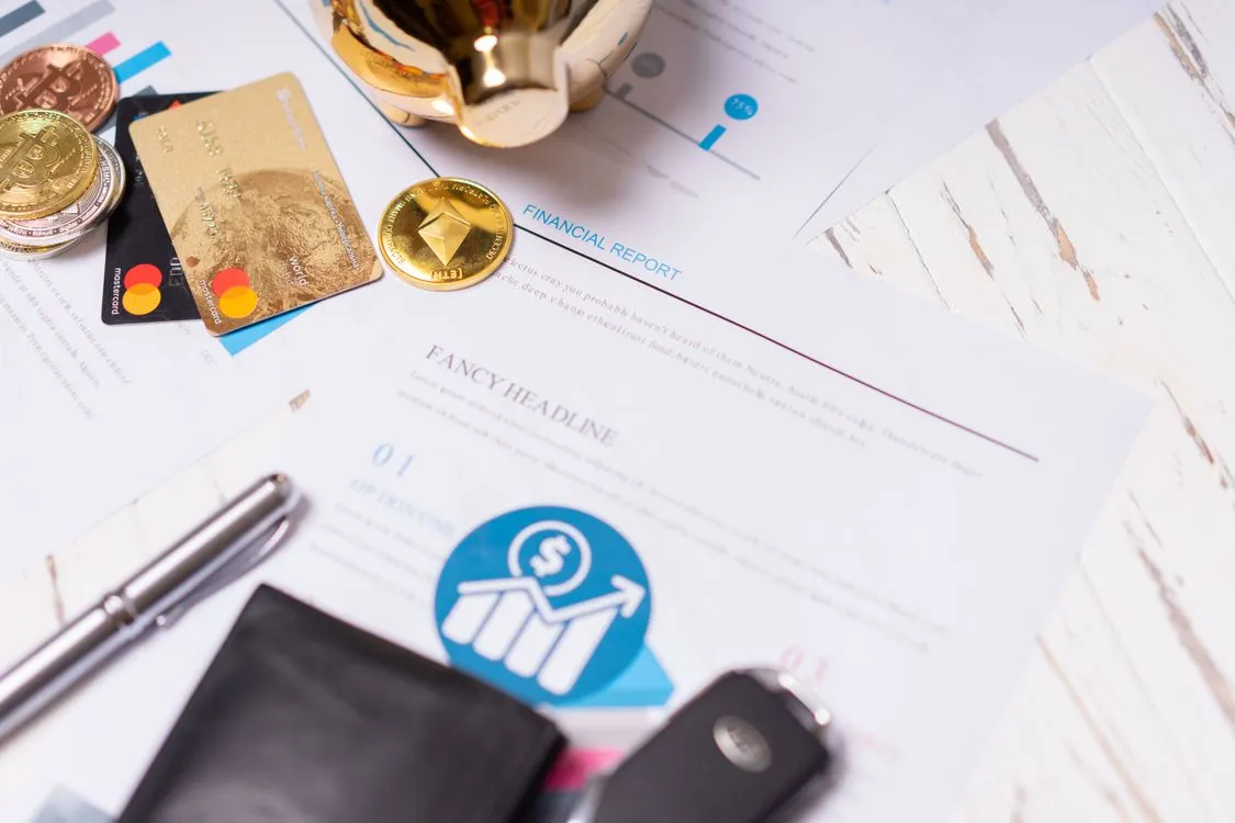 Credit score dial displayed on a laptop screen next to a notepad of figures