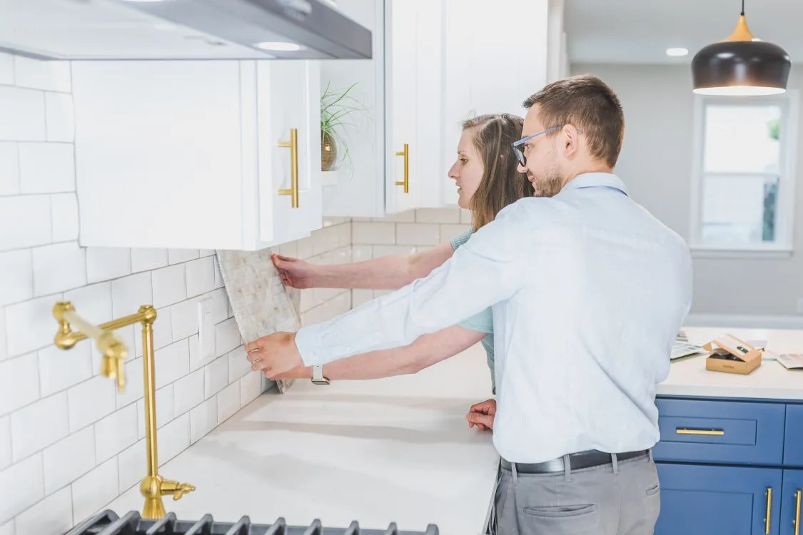 Couple examining backsplash tiles for a kitchen renovation